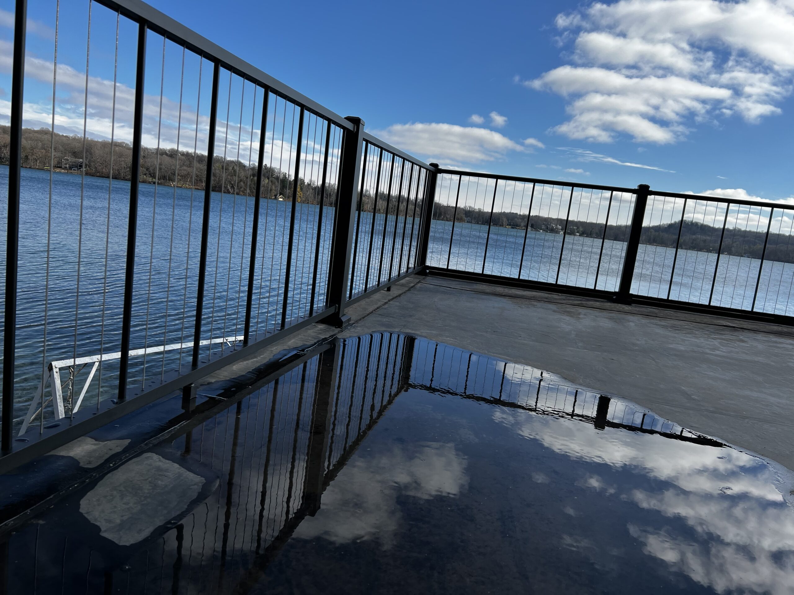 Photo of a composite deck with deck railing on a lakefront property.