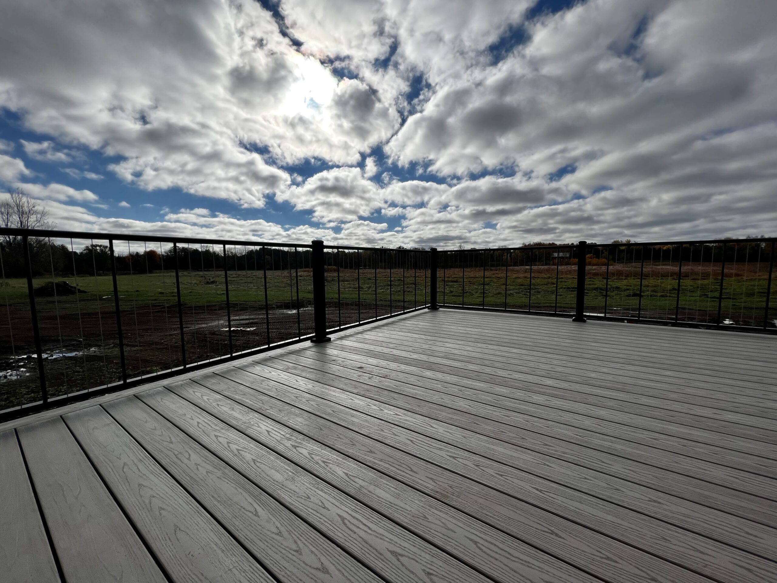 Photo of Composite Deck with Black Railings and Clouds