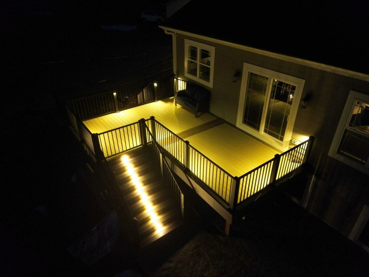 Photo of Composite Deck Illuminated at Night - Custom Covered Deck builder and contractor Washington County, WI