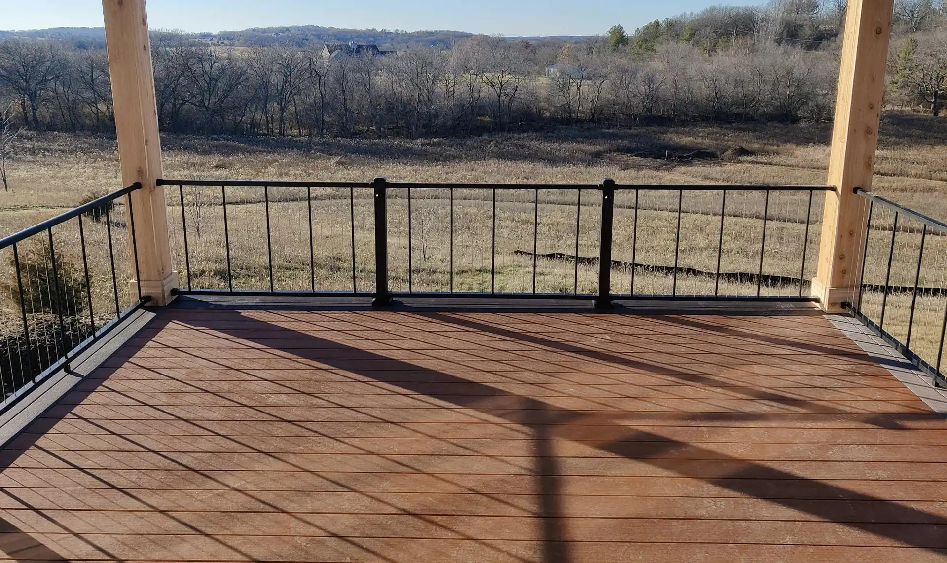 photo of an elevated deck with a beautiful view of the trees out back - Covered porches