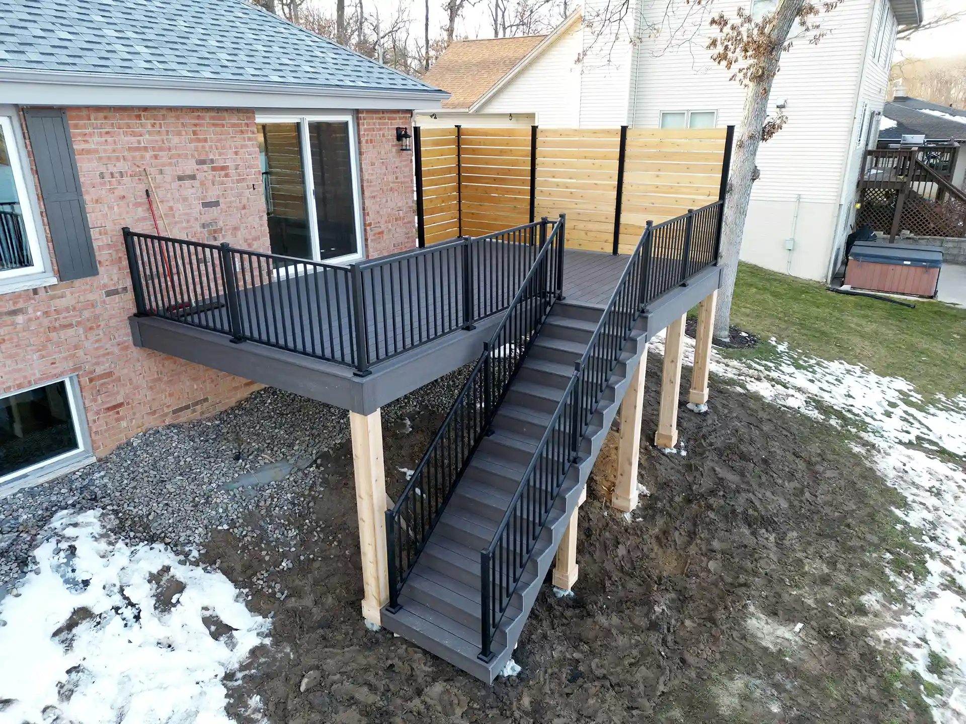 photo of an elevated deck built in winter with deck steps and railing