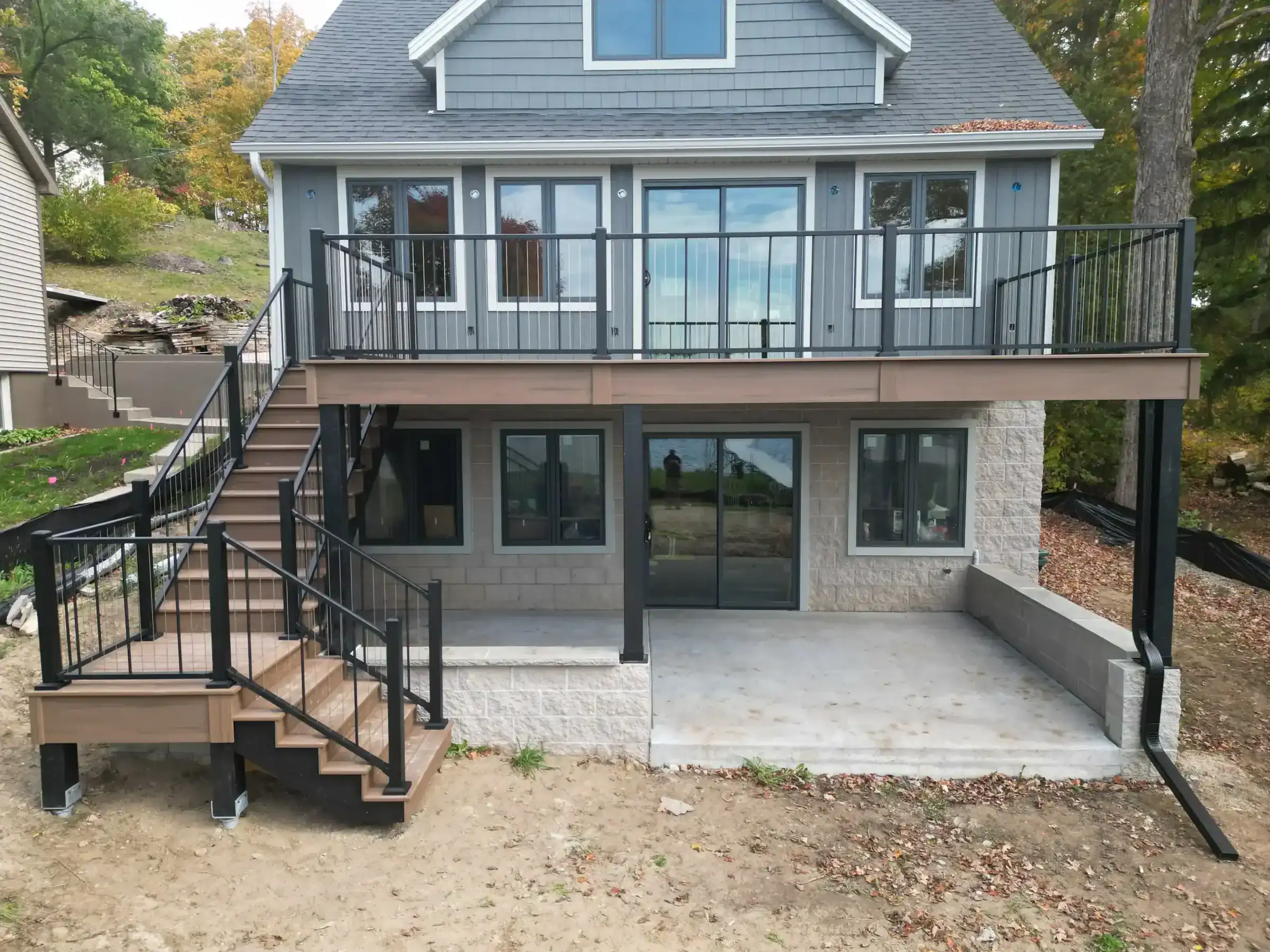 Composite elevated deck with white cable railing with paver below featuring deck framing in slinger wi