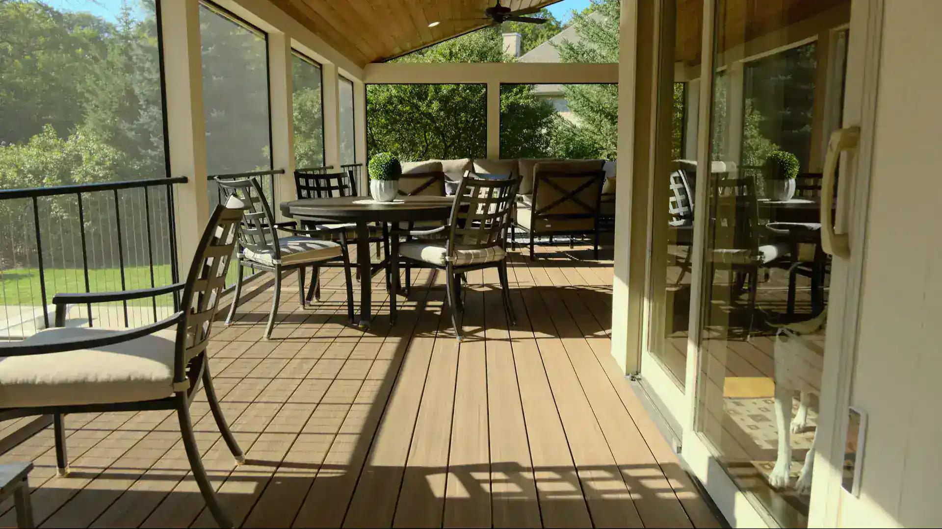 Covered porches with furniture and composite pvc deck featuring trees on the background in slinger wi