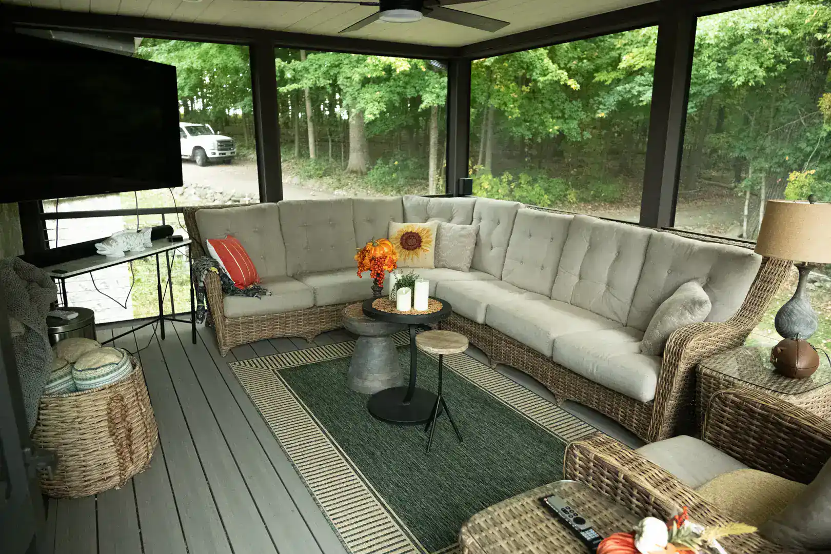 Interior view of screened in porch with composite deck featuring trees on the background in slinger wi