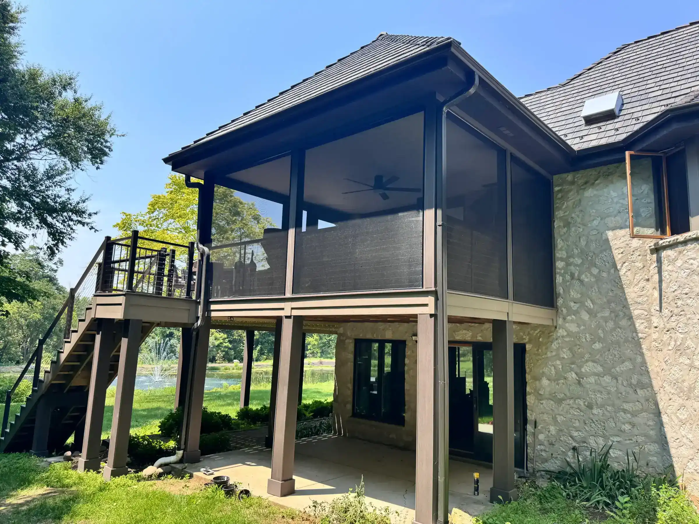 Screened porch in elevated residential deck witth cable railing in slinger wi